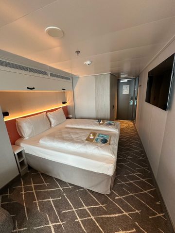 Kabine mit Doppelbett und Fernseher auf der Mein Schiff Relax