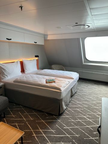 Schlafbereich einer Suite mit großem Fenster auf der Mein Schiff Relax