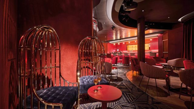 Lounge in Rot mit Käfigsesseln an Bord der Mein Schiff Relax