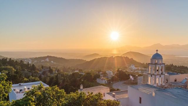 Sonnenuntergang über den Hügeln von Kos mit Kirchturm
