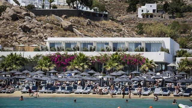 Strand mit Sonnenschirmen vor dem Mykonos Dove Beachfront Hotel