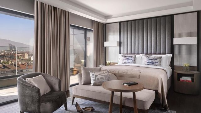 Luxuriöses Hotelzimmer im InterContinental Sofia mit Kingsize-Bett, eleganter Sitzecke, großem Fensterfront-Panorama und stilvollem Interieur mit Blick über die Stadt.